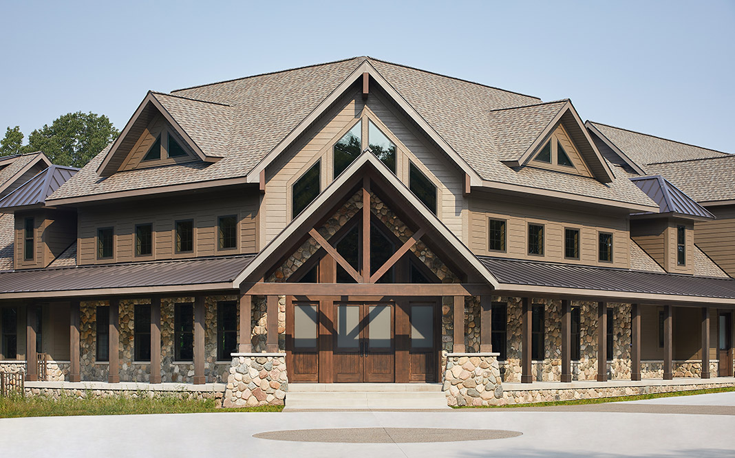 Michigan Cobble glacial fieldstone veneer on the water table, column bases and porch surround of a timber-frame lodge