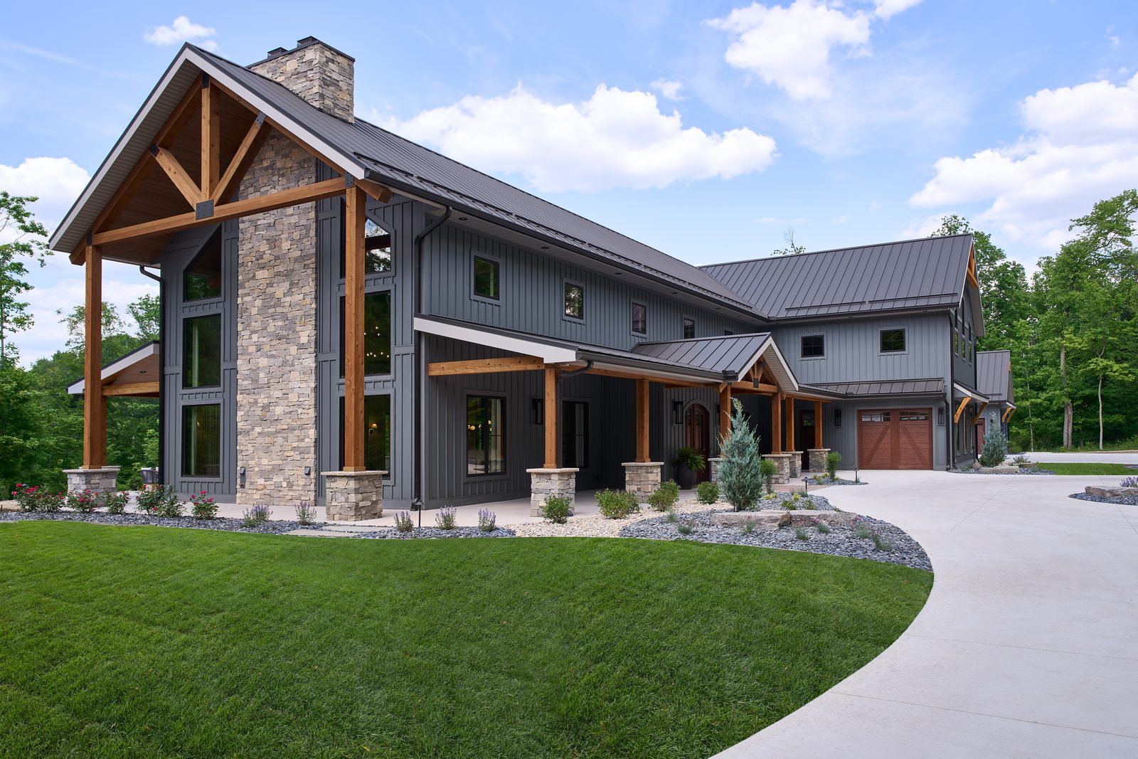 Beach Blend Ashlar limestone chimney on a dark board-and-batten home exterior