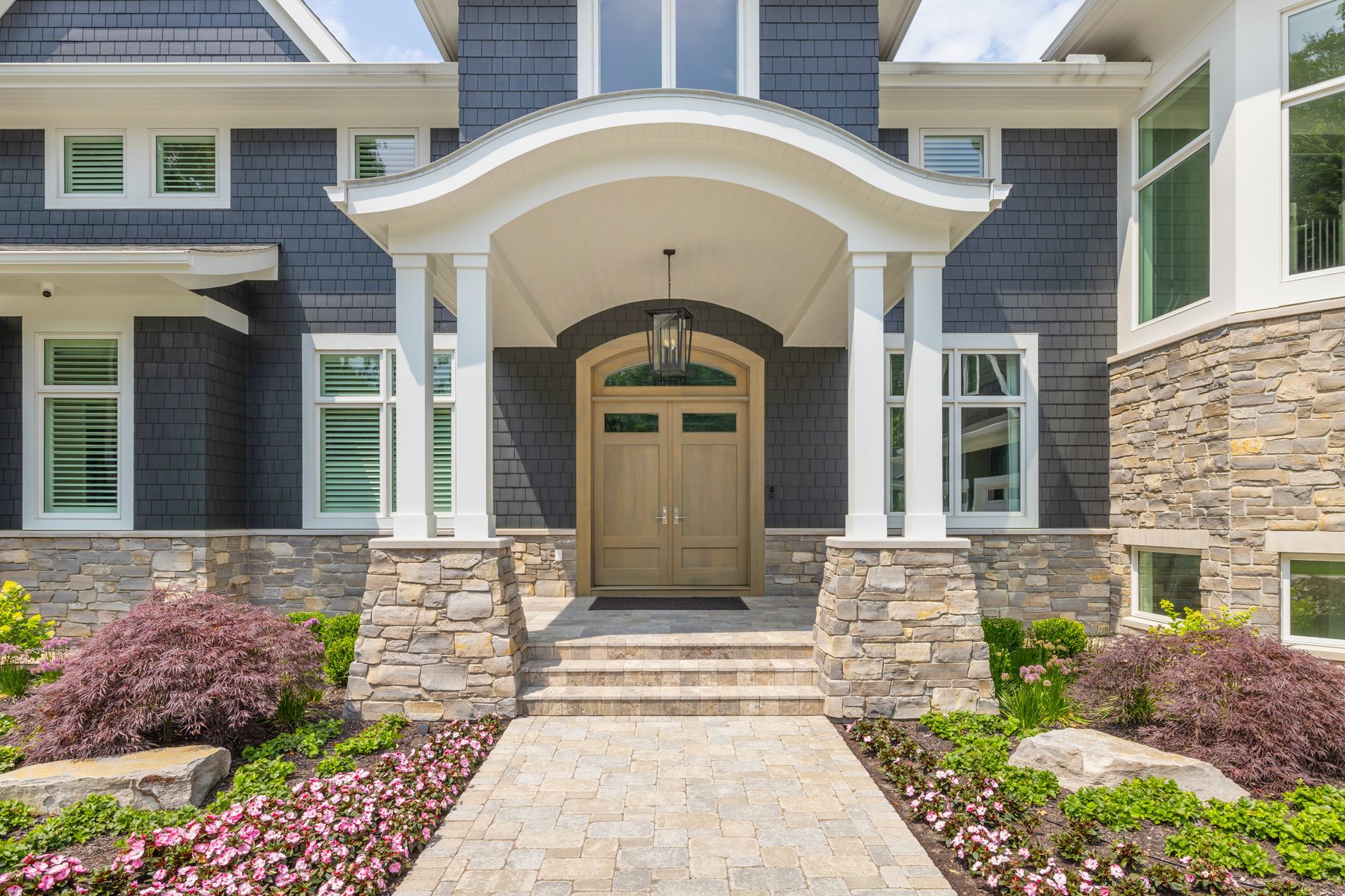 Black River Ashlar natural Michigan stone entry piers and wainscot on a shingle-style home by Mike Schaap Builders